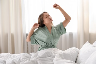 Photo of Beautiful woman stretching in bed at home