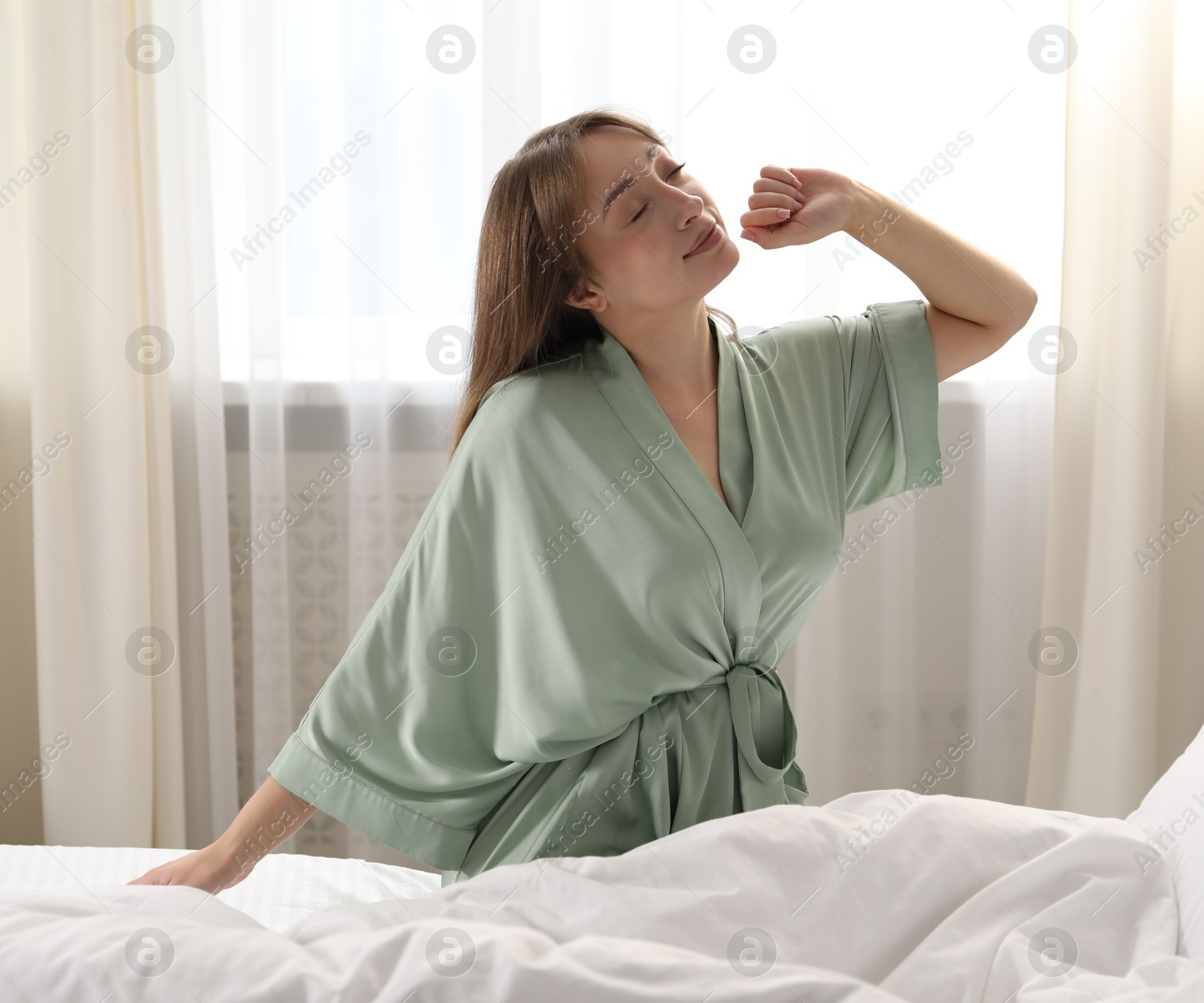 Photo of Beautiful woman stretching in bed at home