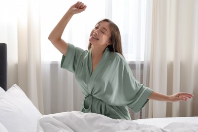 Photo of Beautiful woman stretching in bed at home