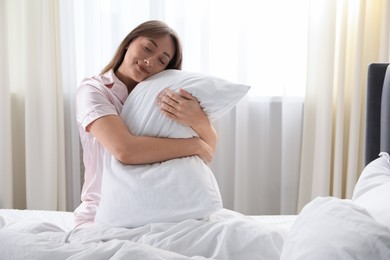 Photo of Beautiful woman with pillow in bed at home
