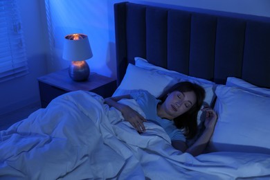 Photo of Beautiful woman sleeping in bed at home, above view
