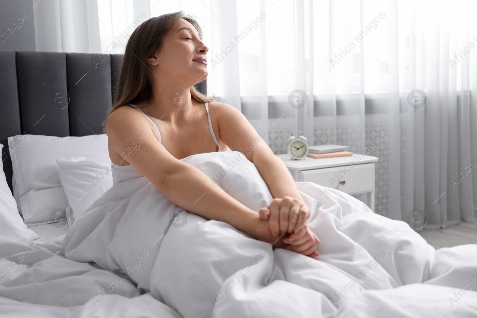 Beautiful woman relaxing in bed at home Photo of Beautiful woman relaxing in bed at home