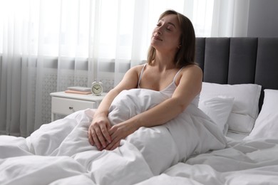 Photo of Beautiful woman relaxing in bed at home