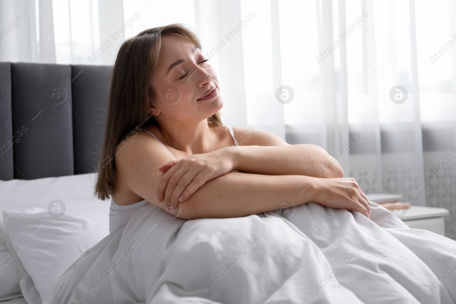 Beautiful woman relaxing in bed at home Photo of Beautiful woman relaxing in bed at home