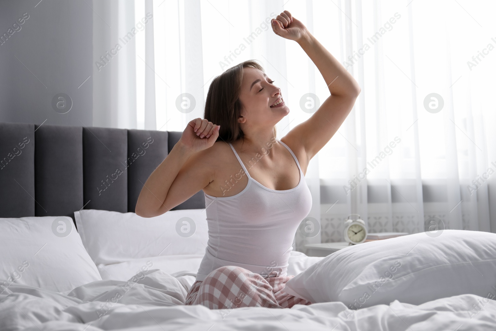Beautiful woman stretching in bed at home Photo of Beautiful woman stretching in bed at home