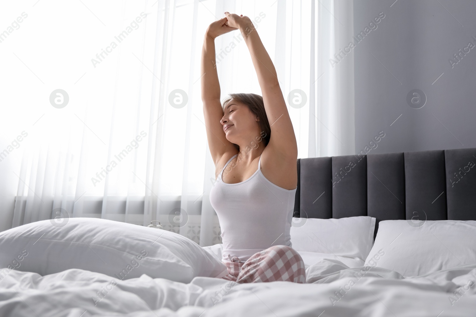 Photo of Beautiful woman stretching in bed at home