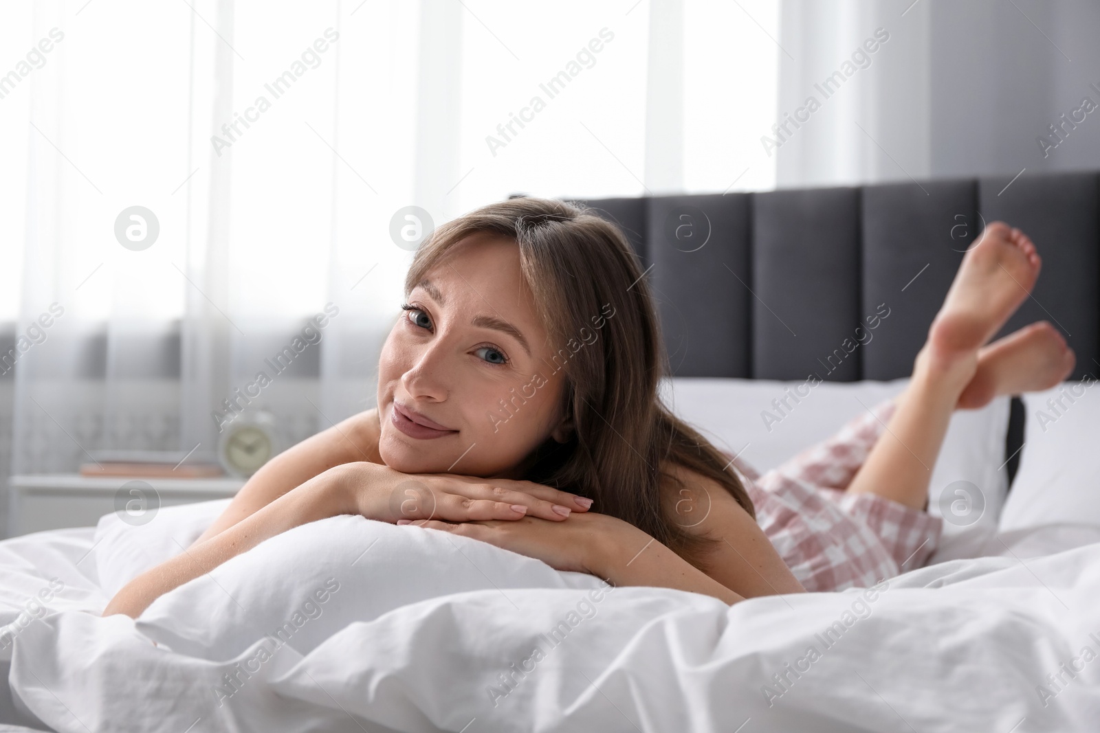 Beautiful woman relaxing on bed at home Photo of Beautiful woman relaxing on bed at home