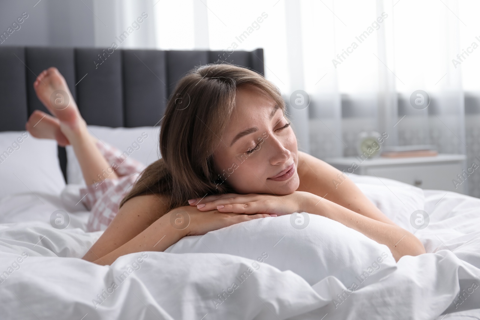 Beautiful woman relaxing on bed at home Photo of Beautiful woman relaxing on bed at home