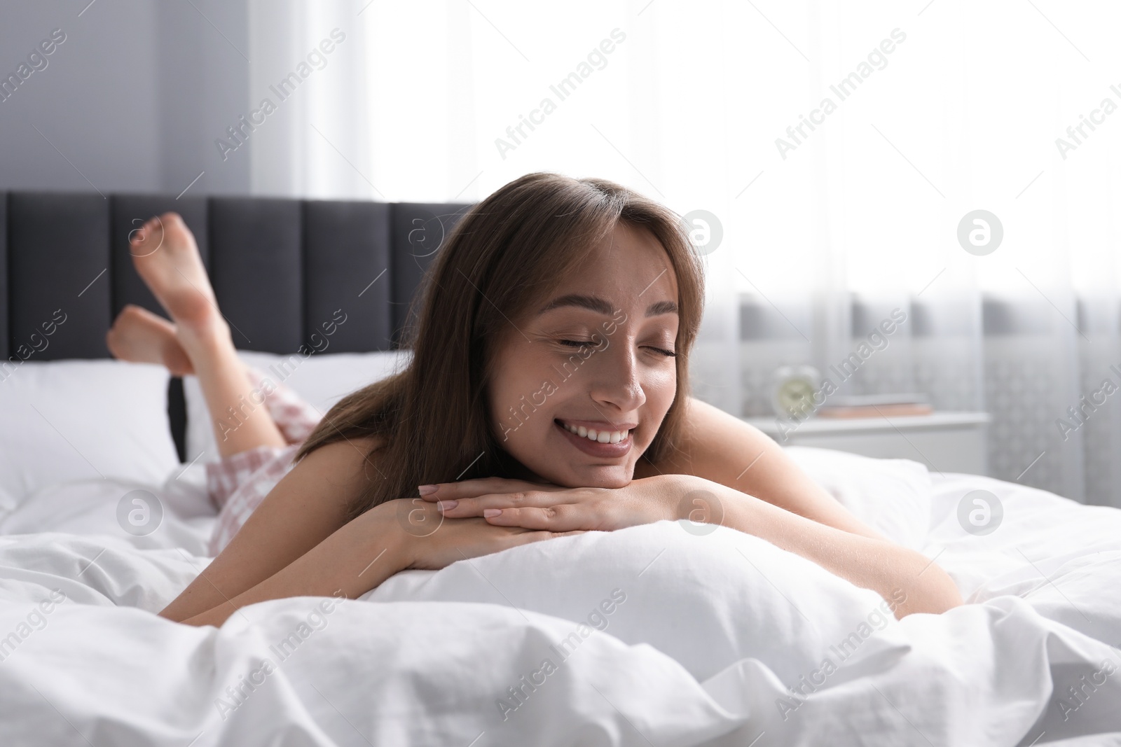 Beautiful woman relaxing on bed at home Photo of Beautiful woman relaxing on bed at home