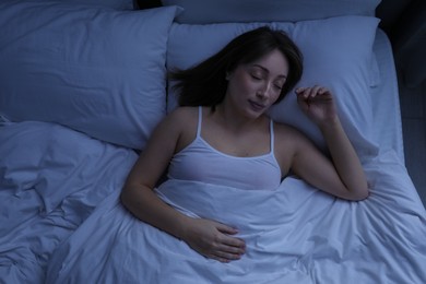 Photo of Beautiful woman sleeping in bed at home, top view