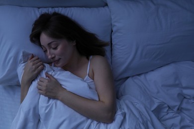 Photo of Beautiful woman sleeping in bed at home, top view