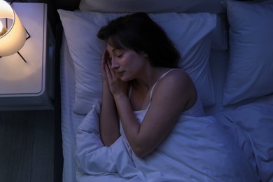 Photo of Beautiful woman sleeping in bed at home, top view