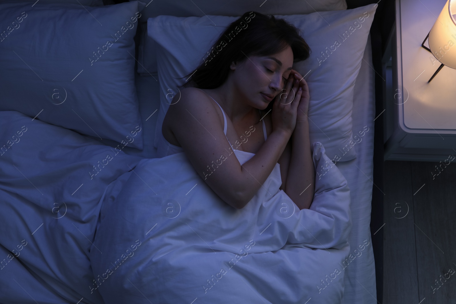 Photo of Beautiful woman sleeping in bed at home, top view