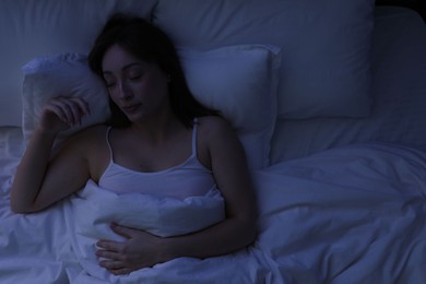 Photo of Beautiful woman sleeping in bed at home, top view
