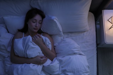 Photo of Beautiful woman sleeping in bed at home, top view