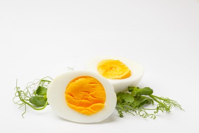Photo of Boiled egg and microgreens on white background