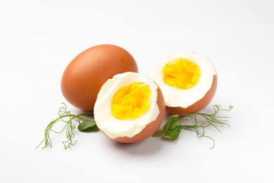 Photo of Hard boiled eggs and microgreens on white background