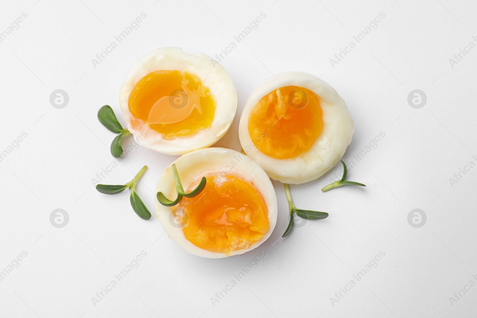 Photo of Soft boiled eggs with microgreens on white background, top view