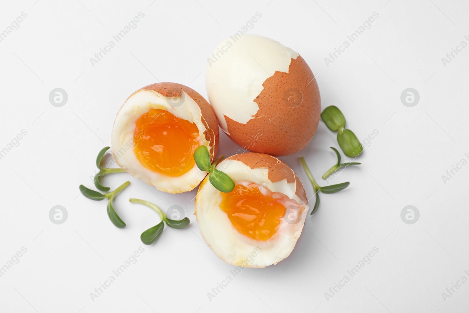Soft boiled eggs with microgreens on white background, top view Photo of Soft boiled eggs with microgreens on white background, top view
