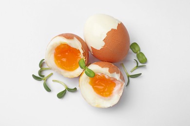 Photo of Soft boiled eggs with microgreens on white background, top view