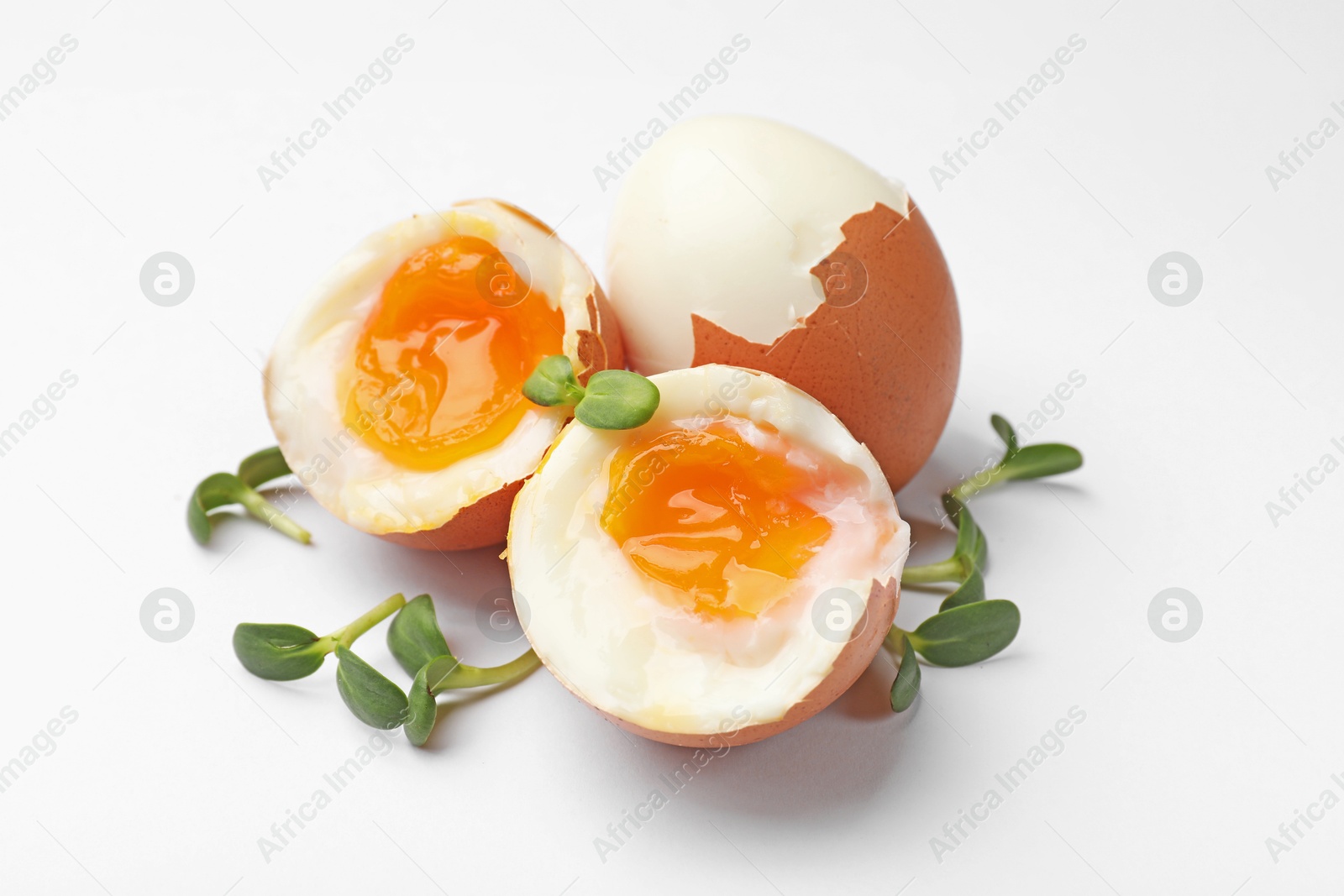 Photo of Soft boiled eggs with microgreens on white background
