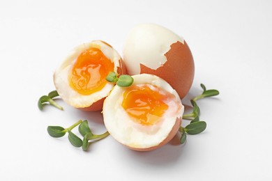 Photo of Soft boiled eggs with microgreens on white background