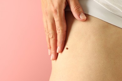 Photo of Woman with mole on her skin against pink background, closeup. Space for text