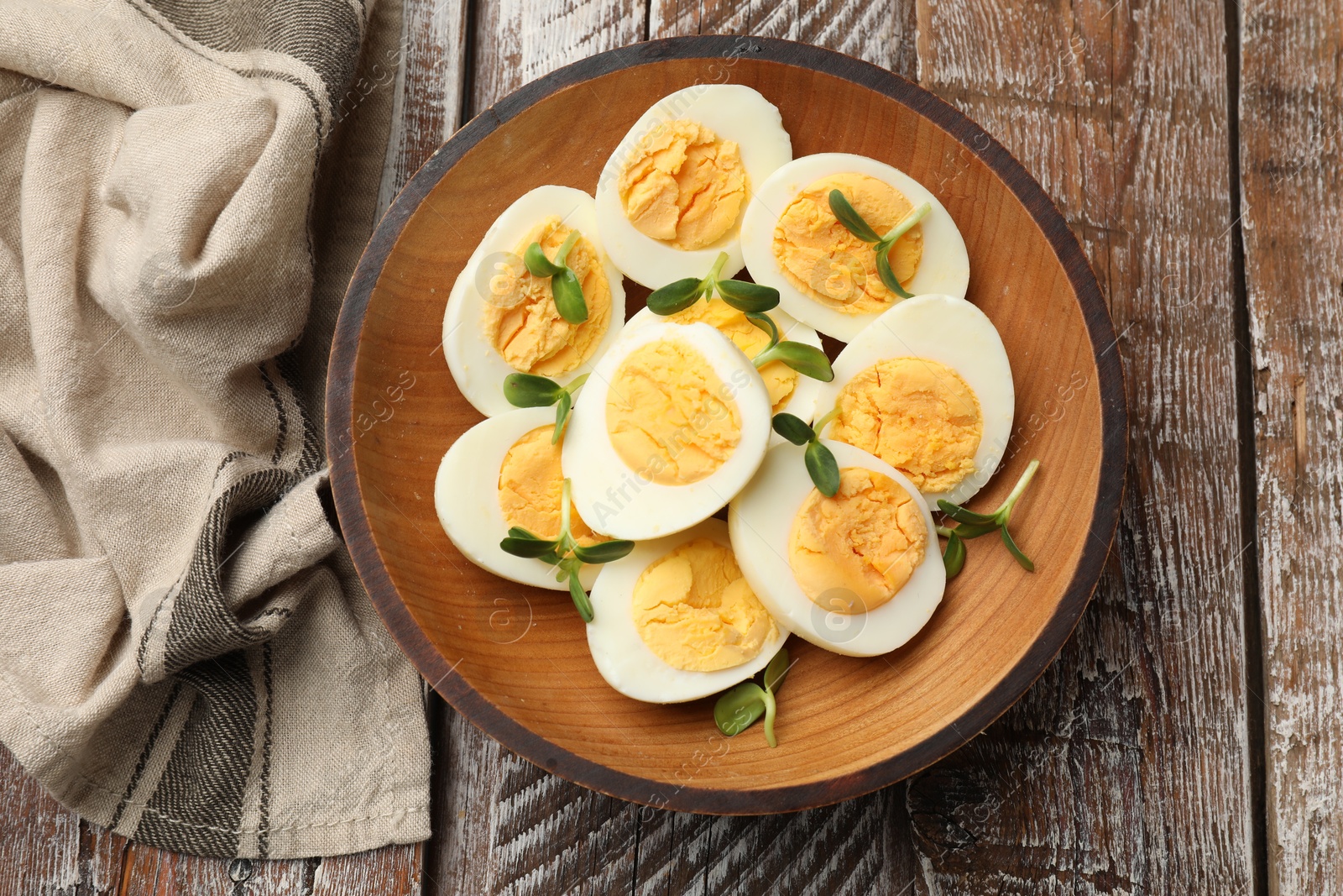 Hard boiled eggs with microgreens on wooden table, top view Photo of Hard boiled eggs with microgreens on wooden table, top view