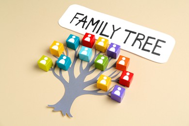 Image of Family tree. Colorful cubes with human icons and paper tree on beige background