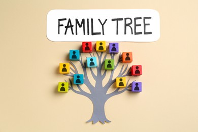 Image of Family tree. Colorful cubes with human icons and paper tree on beige background, top view