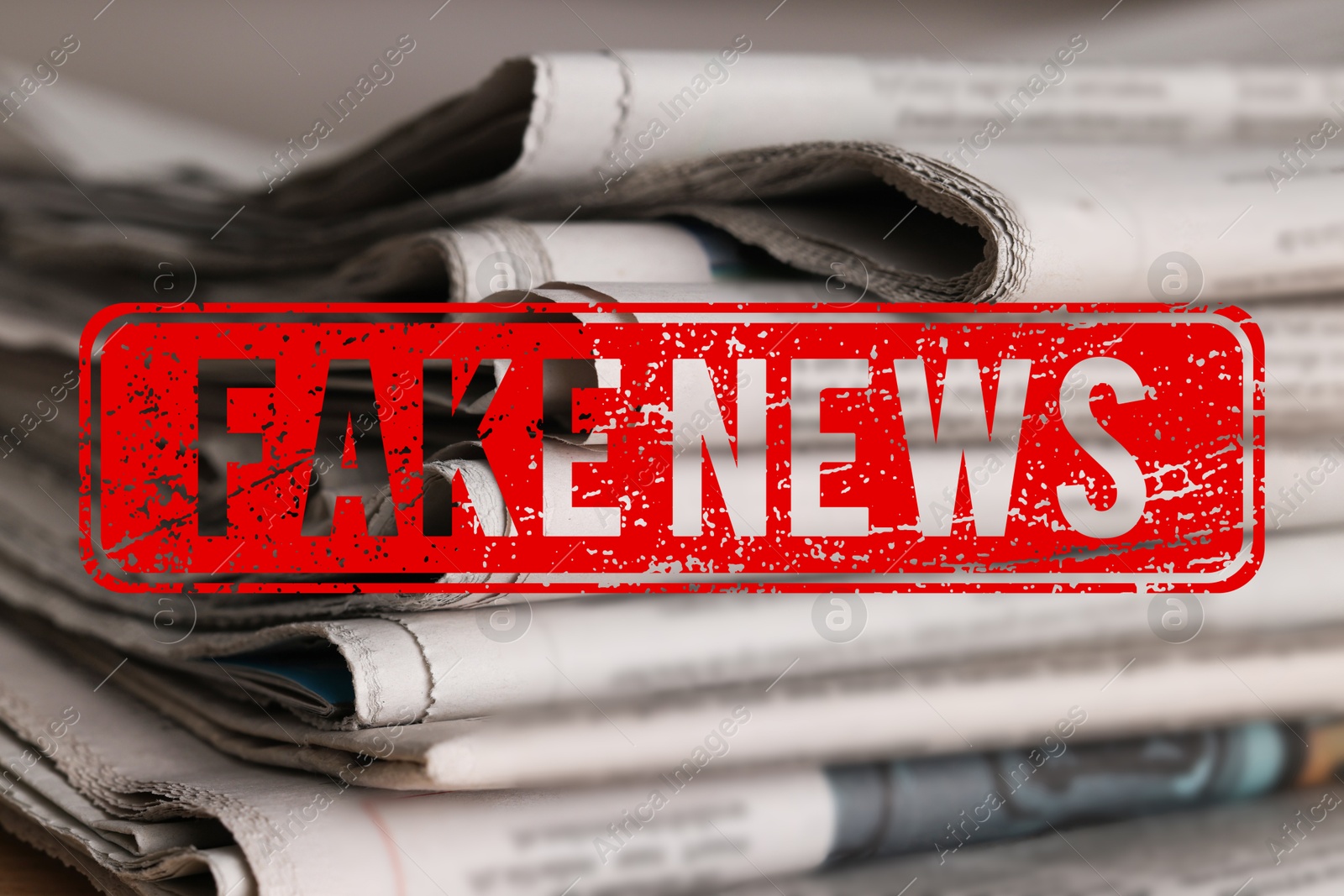 Red Fake News stamp and newspapers on table, closeup Image of Red Fake News stamp and newspapers on table, closeup