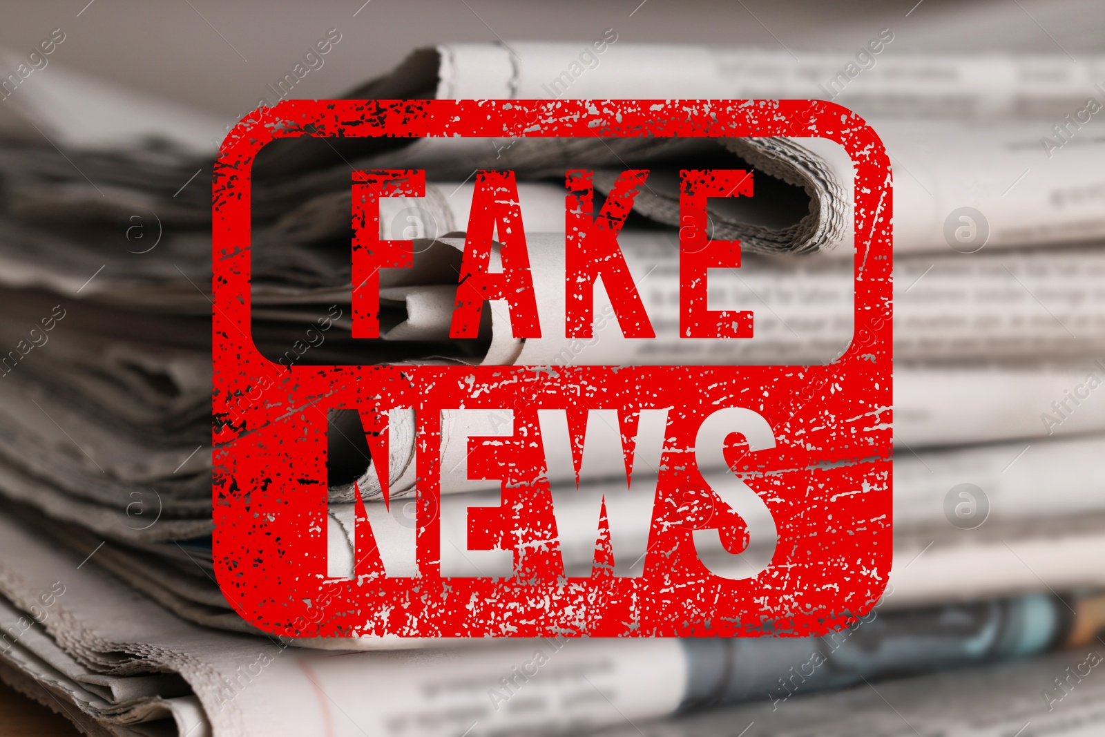 Red Fake News stamp and newspapers on table, closeup Image of Red Fake News stamp and newspapers on table, closeup
