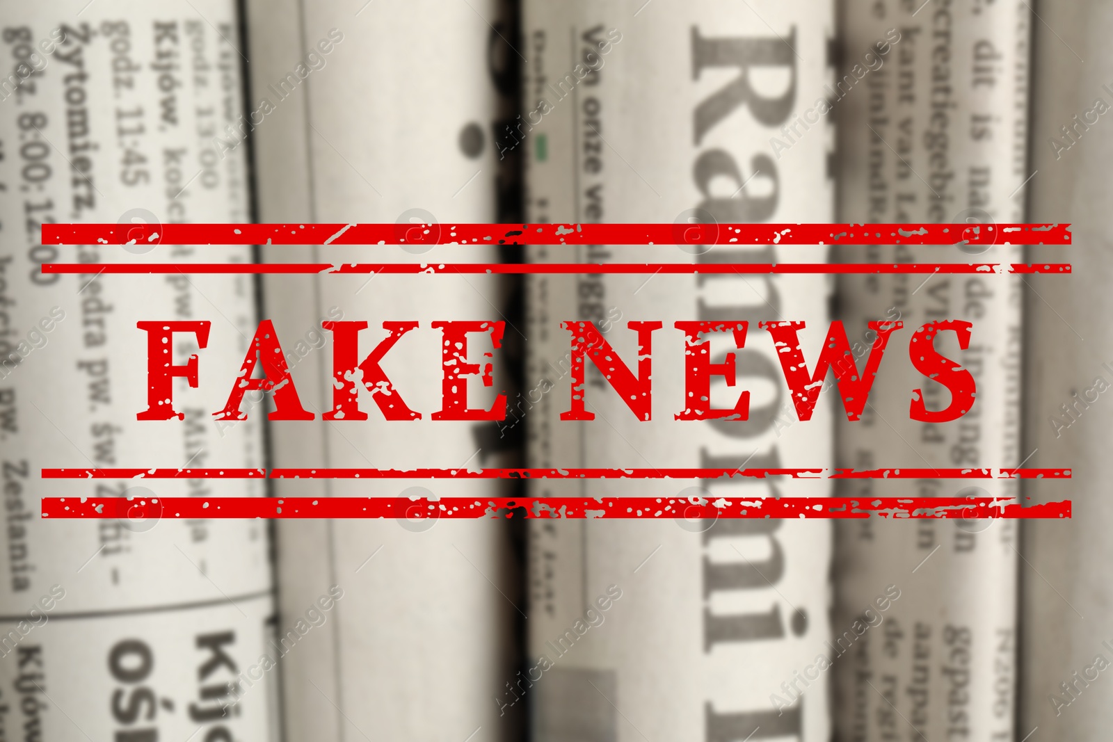 Red Fake News stamp and newspapers in different languages as background, closeup Image of Red Fake News stamp and newspapers in different languages as background, closeup