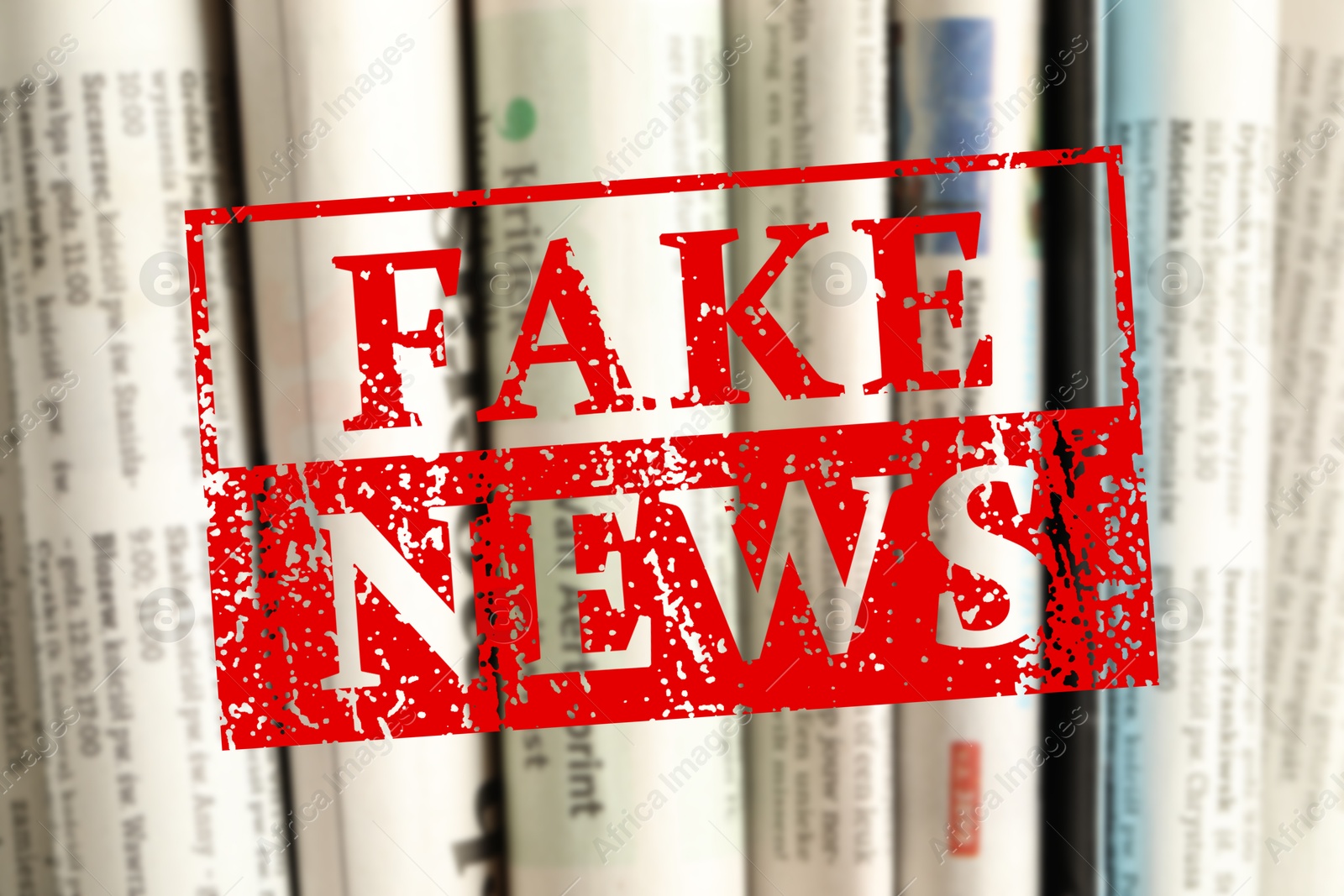 Red Fake News stamp and newspapers as background, closeup Image of Red Fake News stamp and newspapers as background, closeup