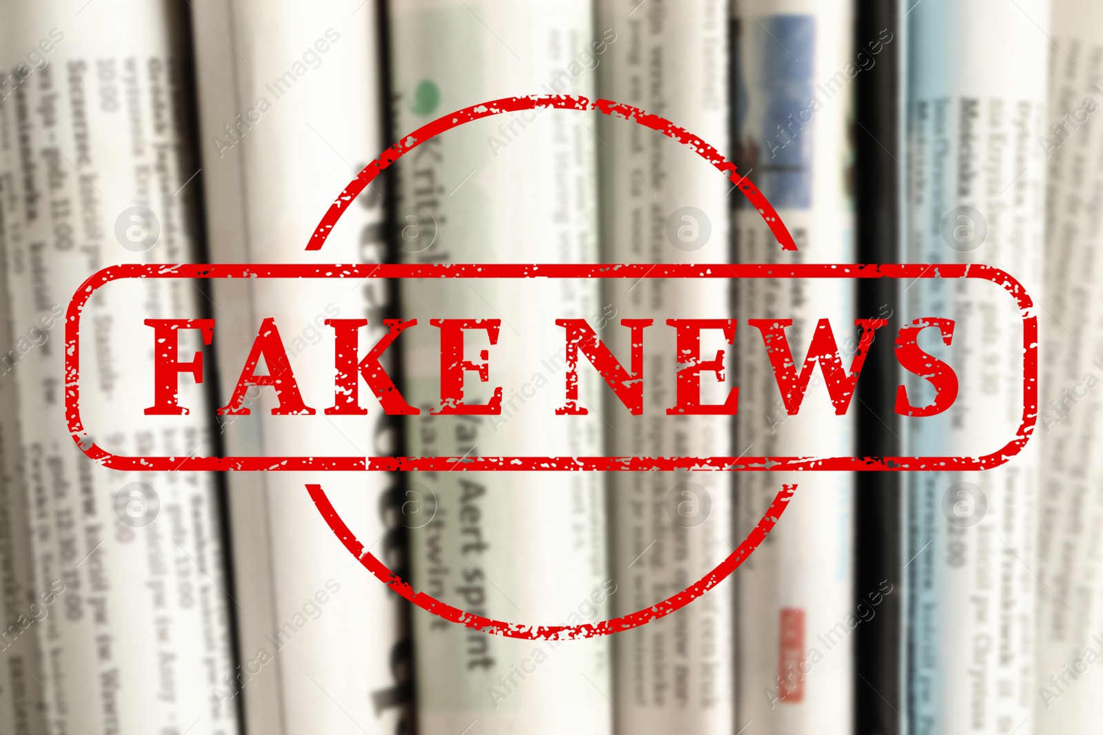 Red Fake News stamp and newspapers as background, closeup Image of Red Fake News stamp and newspapers as background, closeup