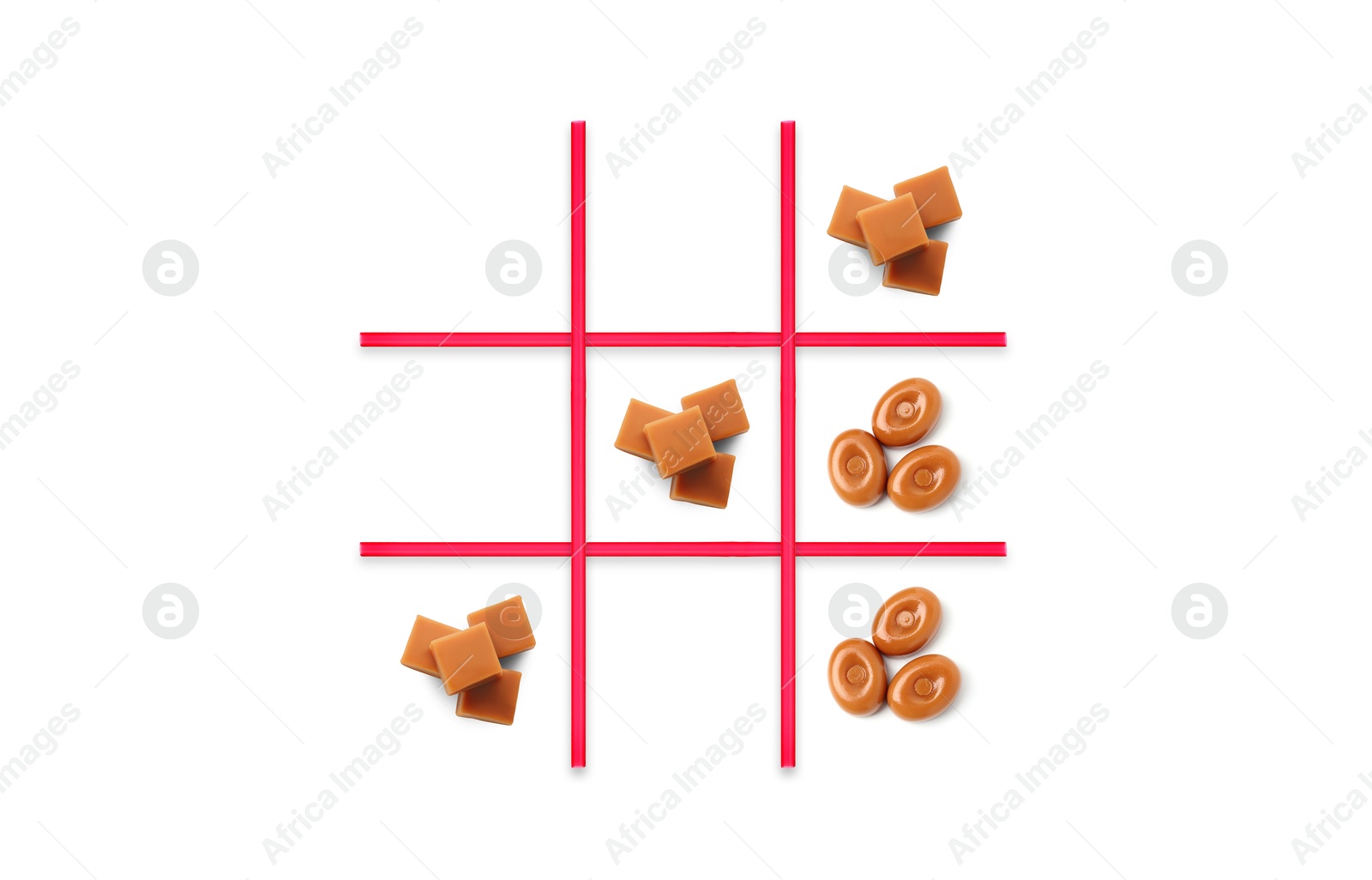 Tic-tac-toe game made of hard toffee and caramel candies on white background, top view Image of Tic-tac-toe game made of hard toffee and caramel candies on white background, top view
