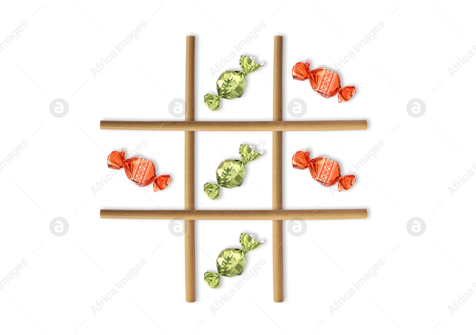 Tic-tac-toe game made of different candies and drinking straws on white background, top view Image of Tic-tac-toe game made of different candies and drinking straws on white background, top view