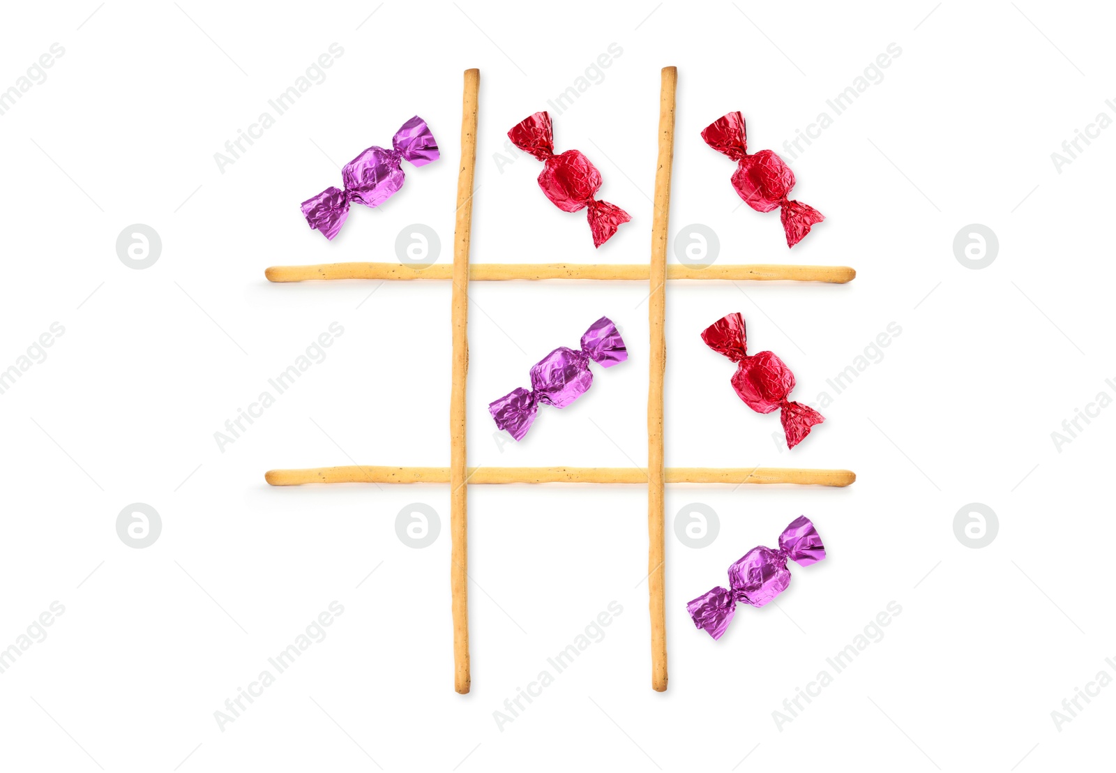 Tic-tac-toe game made of different candies and grissini sticks on white background, top view Image of Tic-tac-toe game made of different candies and grissini sticks on white background, top view