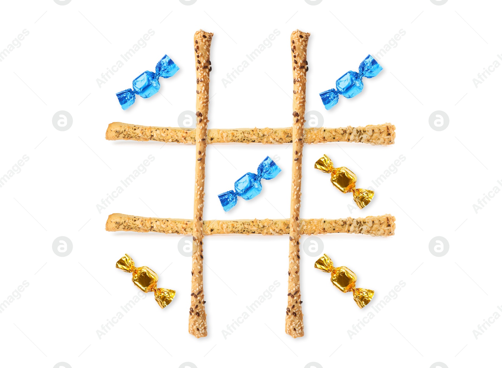 Tic-tac-toe game made of different candies and grissini sticks on white background, top view Image of Tic-tac-toe game made of different candies and grissini sticks on white background, top view
