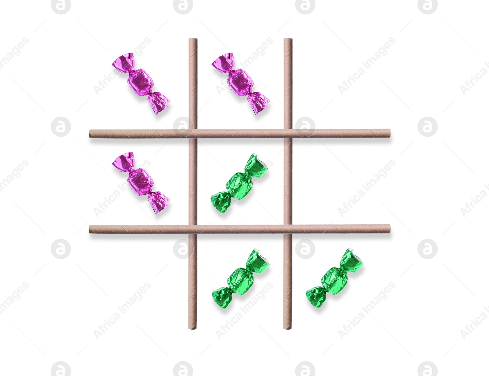 Tic-tac-toe game made of different candies and drinking straws on white background, top view Image of Tic-tac-toe game made of different candies and drinking straws on white background, top view