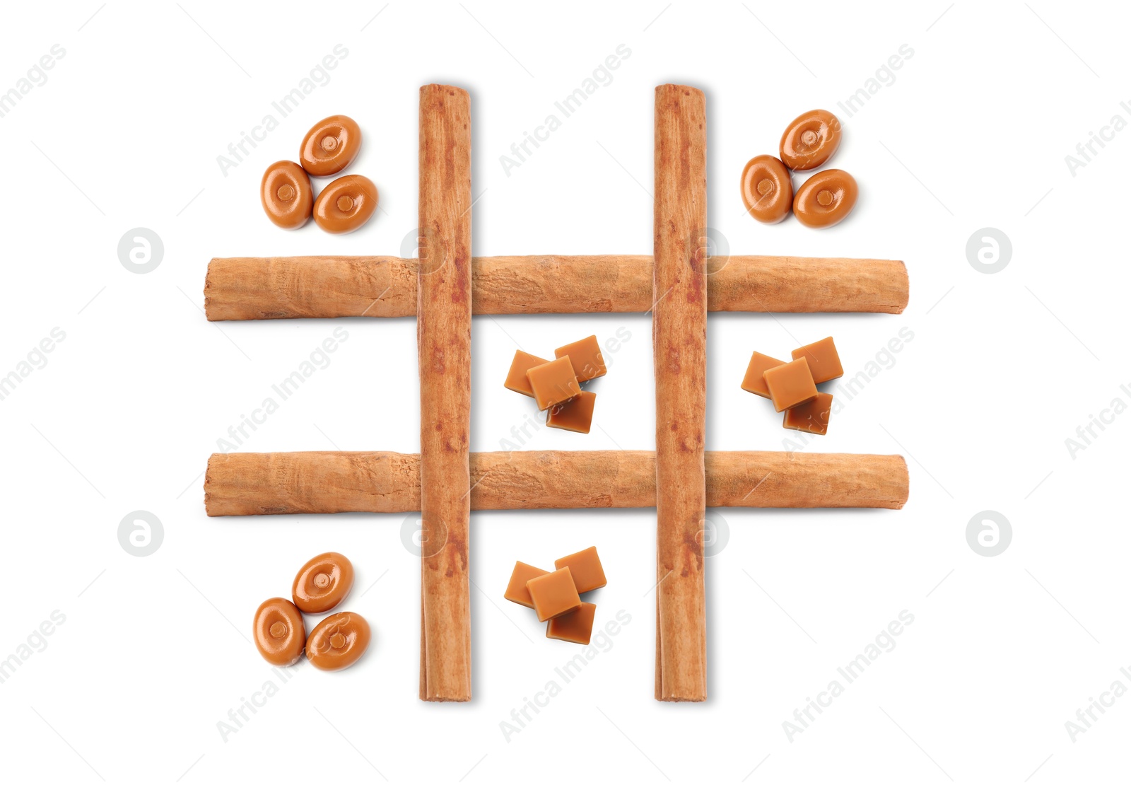 Tic-tac-toe game made of hard toffee and caramel candies on white background, top view Image of Tic-tac-toe game made of hard toffee and caramel candies on white background, top view