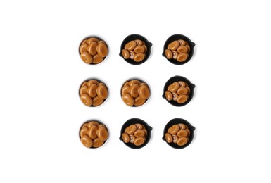 Image of Tic-tac-toe game made of gard toffee candies in different containers on white background