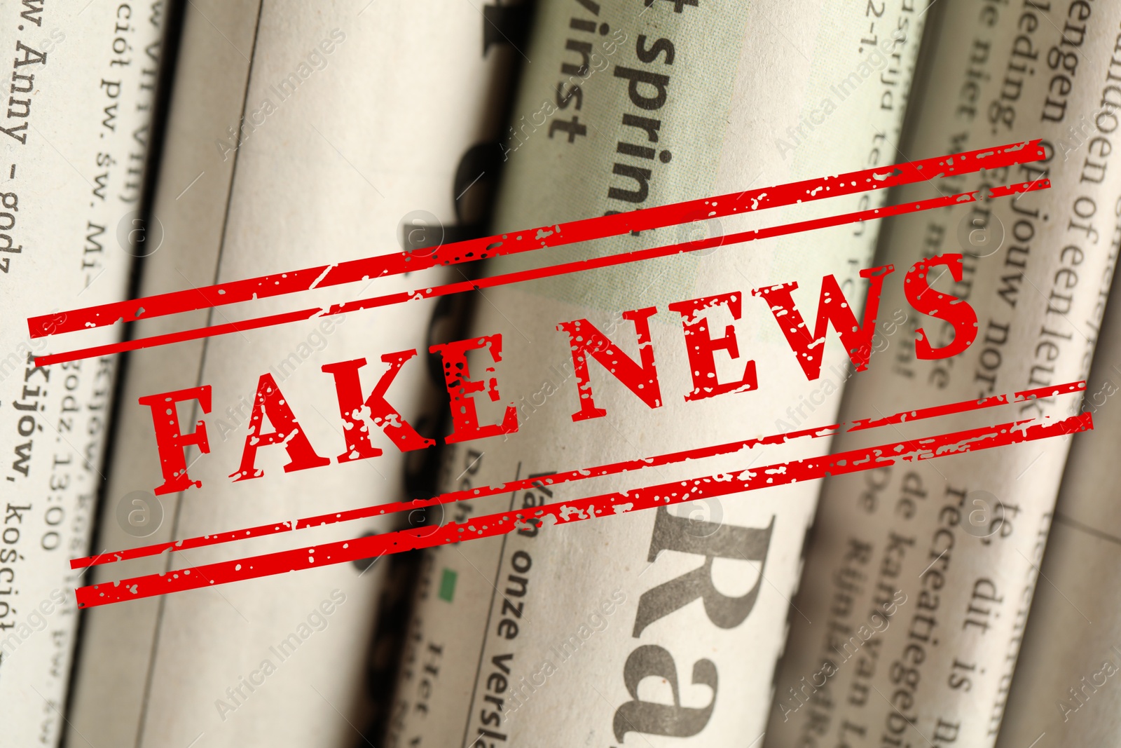 Red Fake News stamp and newspapers in different languages as background, closeup Image of Red Fake News stamp and newspapers in different languages as background, closeup