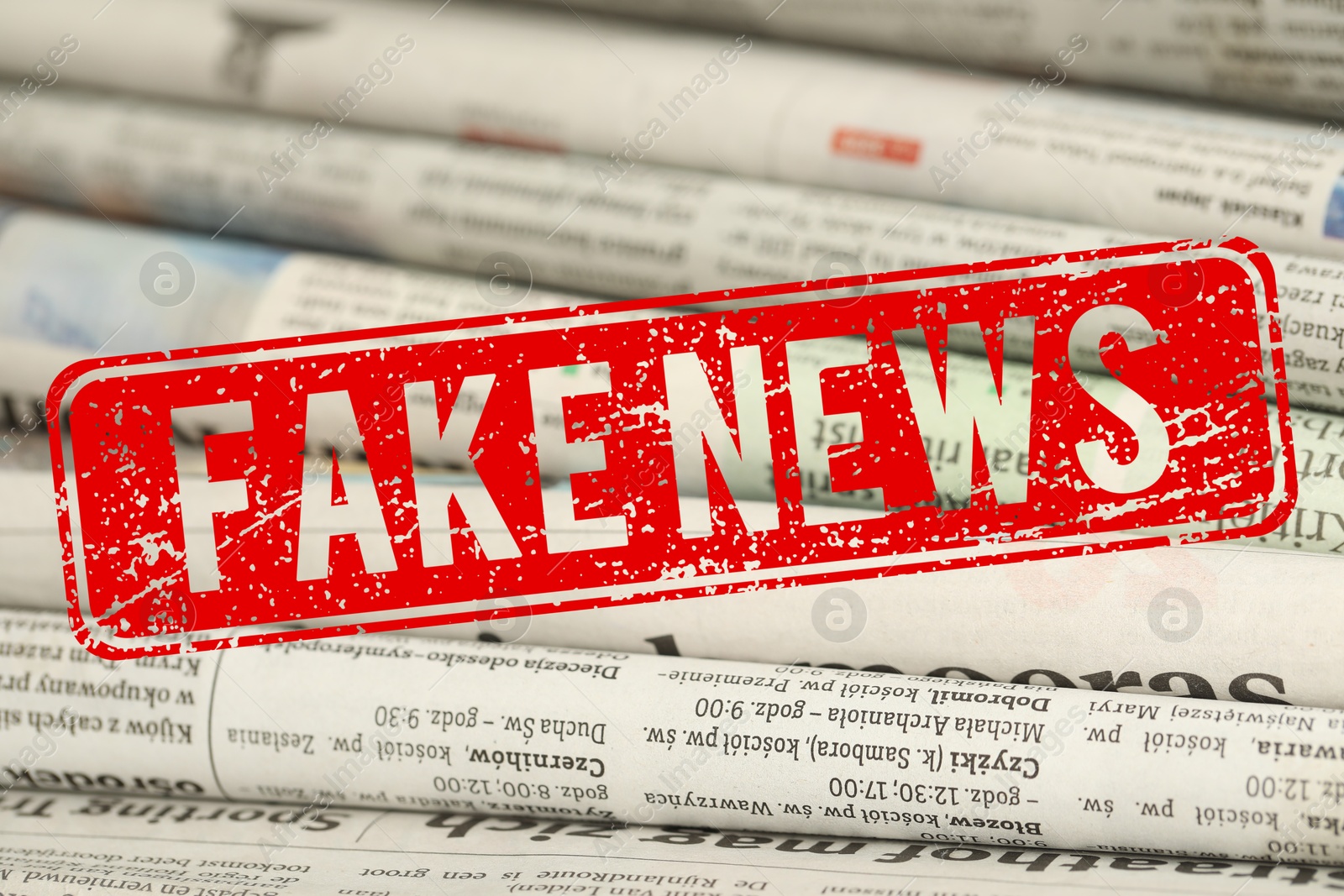 Red Fake News stamp and newspapers as background, closeup Image of Red Fake News stamp and newspapers as background, closeup