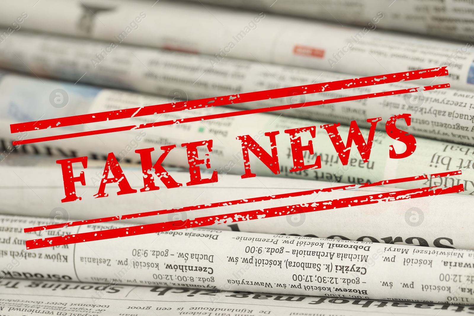 Red Fake News stamp and newspapers as background, closeup Image of Red Fake News stamp and newspapers as background, closeup