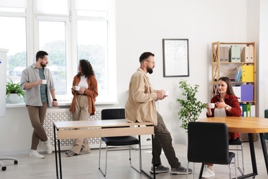 Photo of Colleagues chatting during coffee break in office