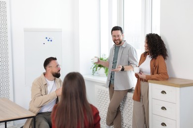 Photo of Colleagues chatting during coffee break in office