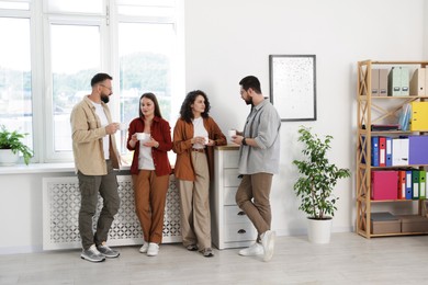 Photo of Colleagues chatting during coffee break in office