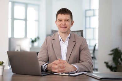Photo of Portrait of handsome man at desk in office