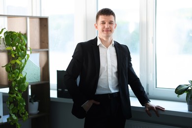 Photo of Portrait of handsome man near window indoors